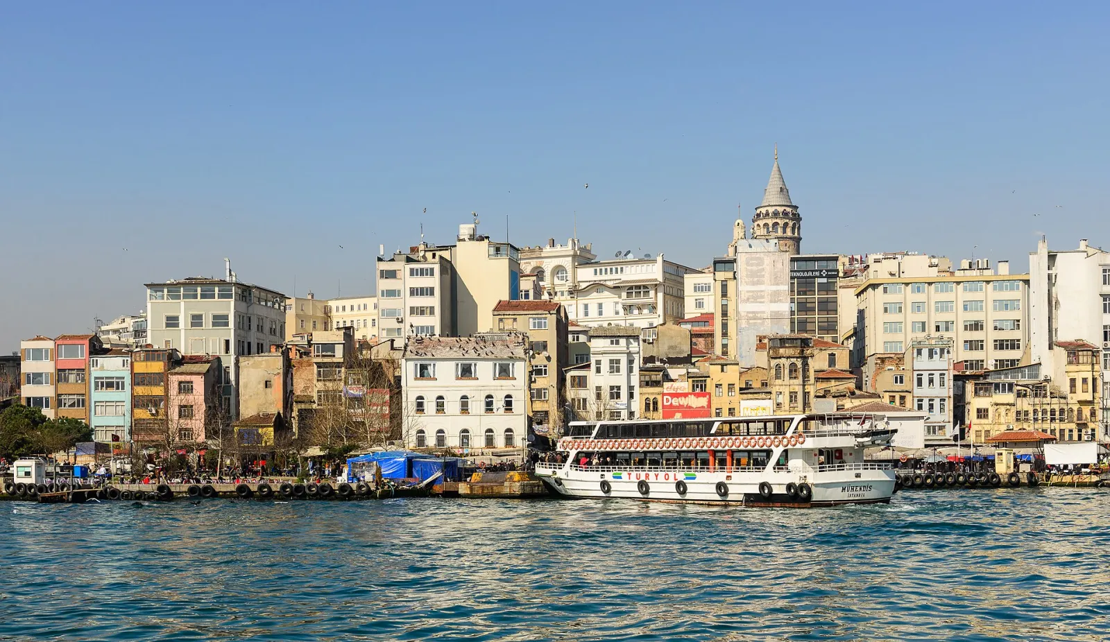 Das Ufer von Karaköy von der Galatabrücke aus, oben auf dem Hügel der Galataturm, davor eine Fähre