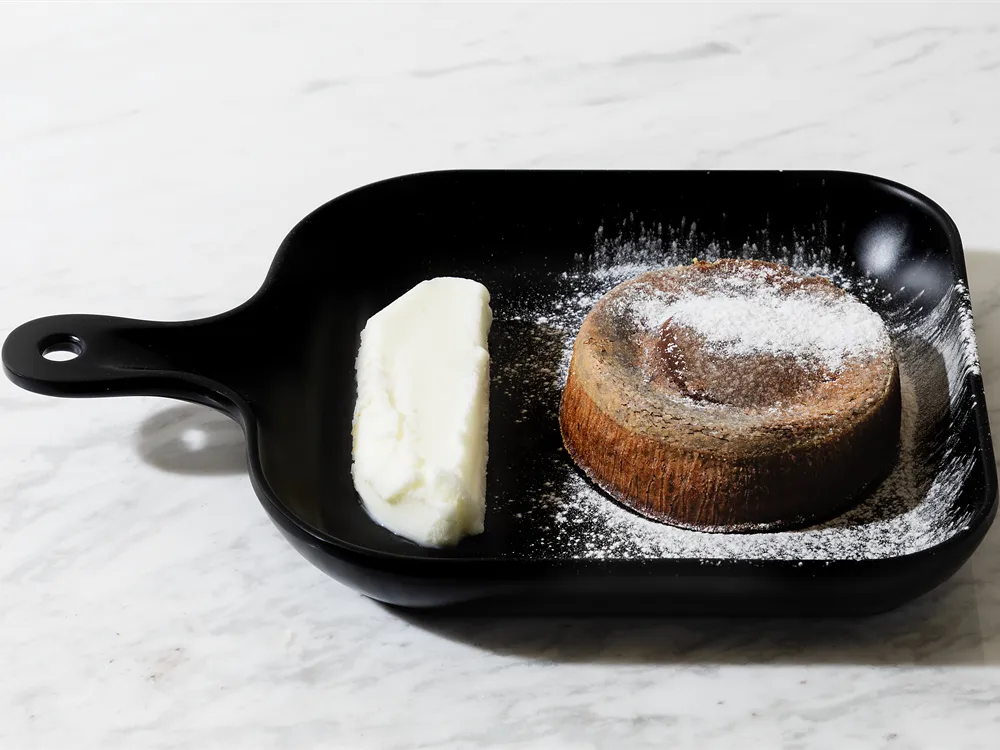 Schokoladensoufflé mit Eis von HR Italy: mit Puderzucker bestäubtes Schokoladensoufflé und Vanilleeis