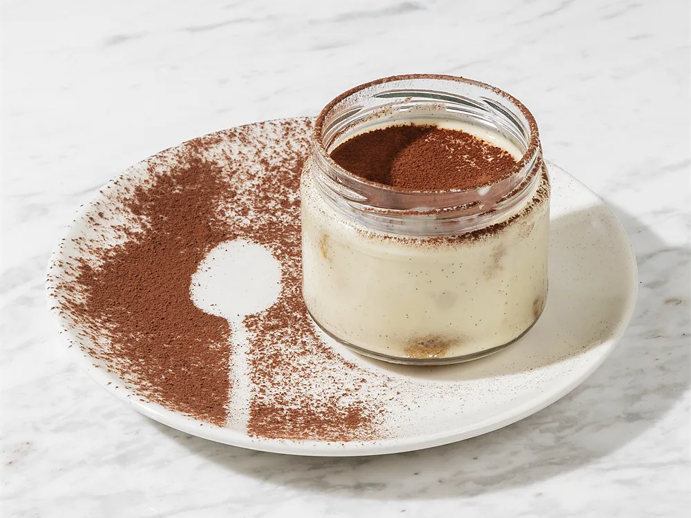 Italienisches Tiramisu von HR Italy: Tiramisu im Glas, auf dem Teller ein Löffelmotiv aus Kakao