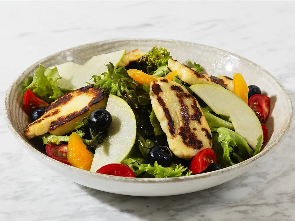 Salat mit gegrilltem Halloumi von HR Italy: gegrillte Halloumischeiben, Kirschtomaten und schwarze Oliven auf Blattsalat