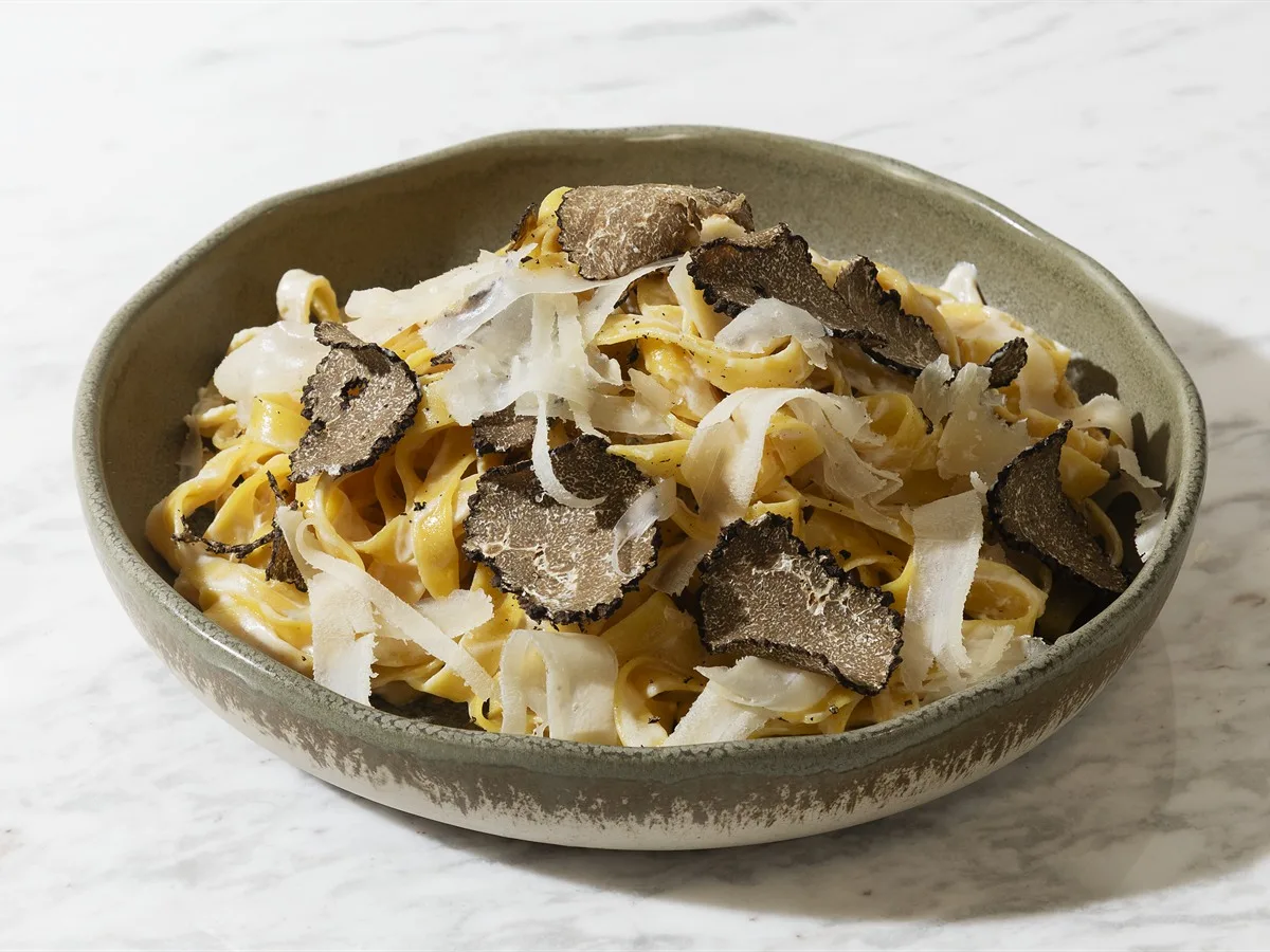 Semolina unundan taze fettuccine; üzerinde siyah trüf dilimleri ve parmesan yongaları
